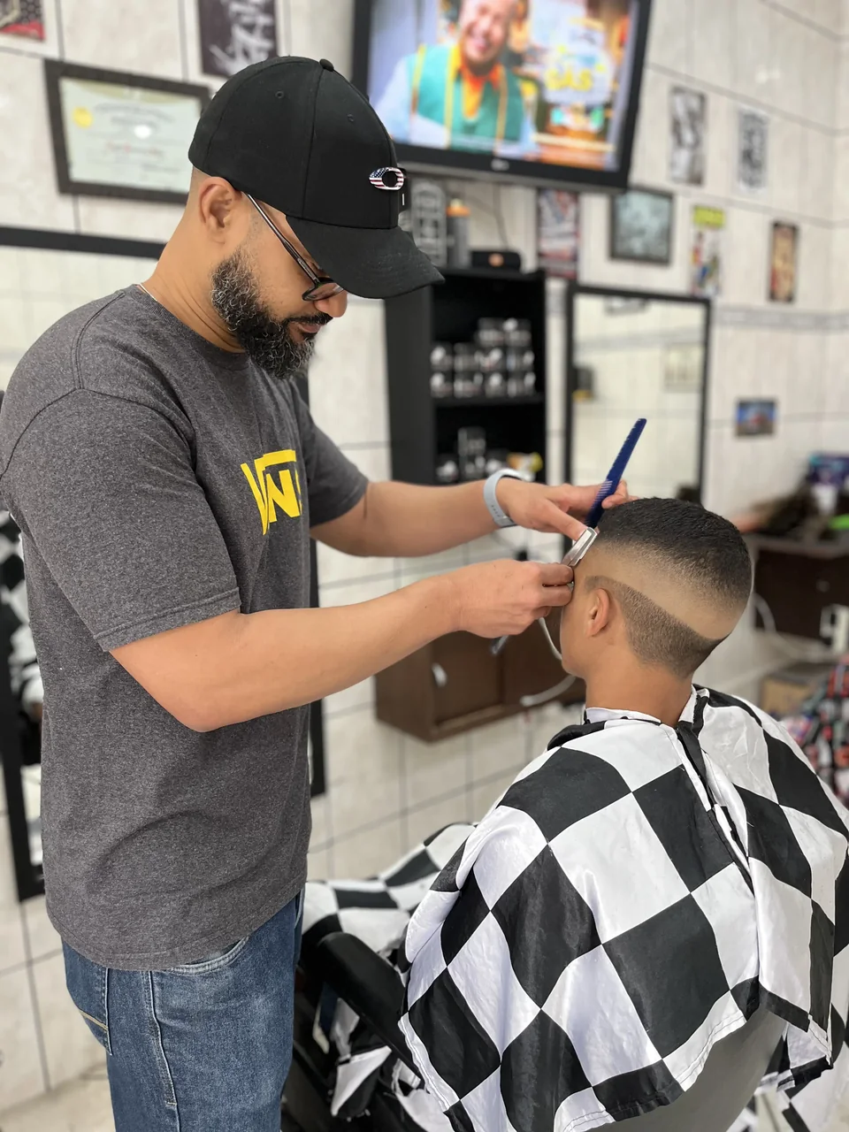 Barbeiro realizando o acabamento do corte de um cliente