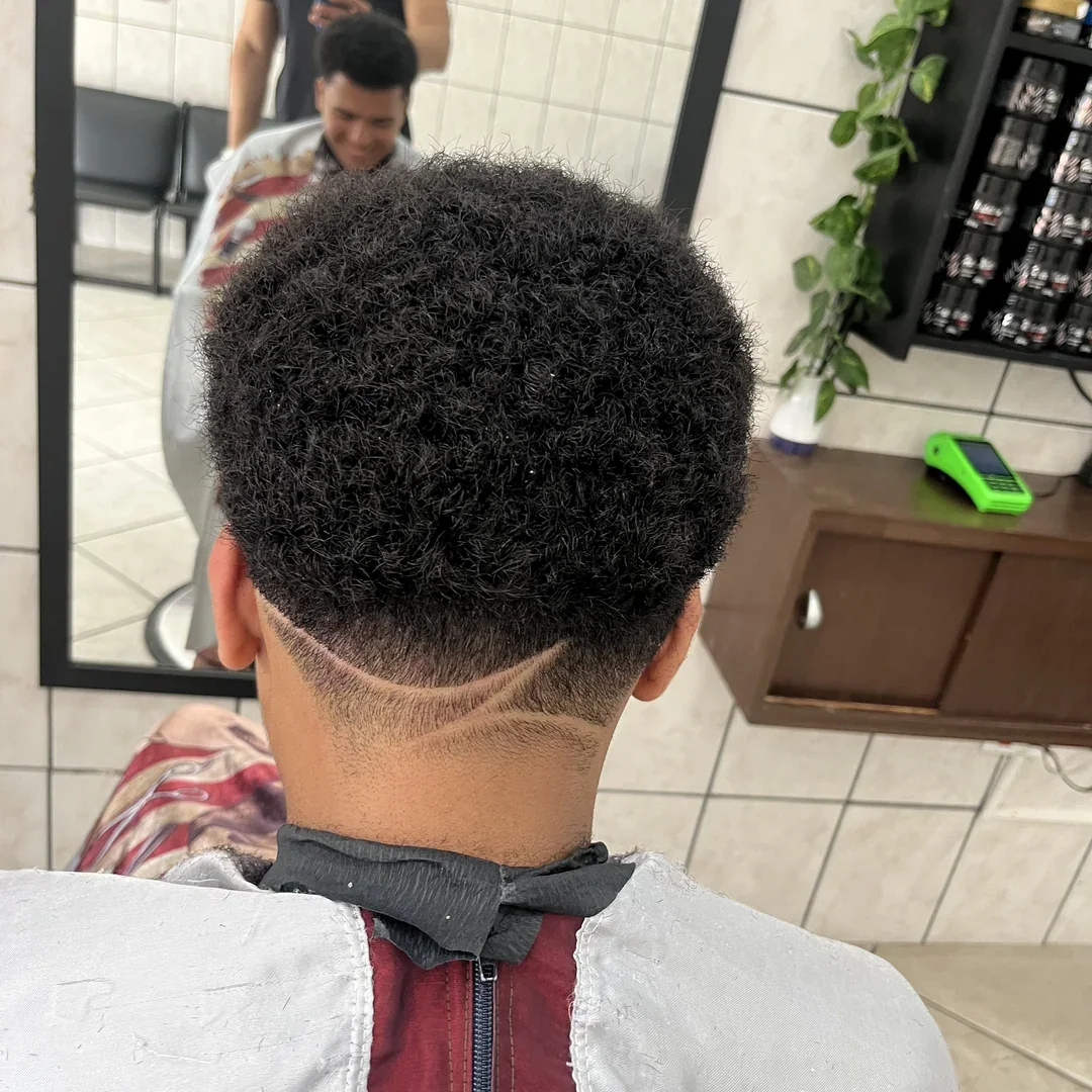 Cliente com cabelo cacheado e desenho no acabamento traseiro