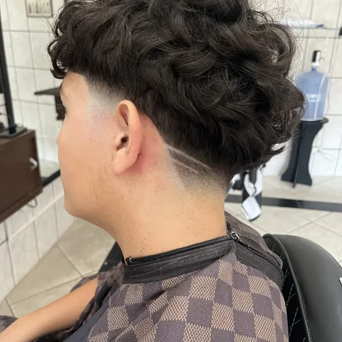 Barbeiro trabalhando no acabamento de um cliente