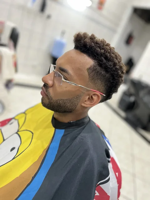 Corte cacheado com degradê e óculos